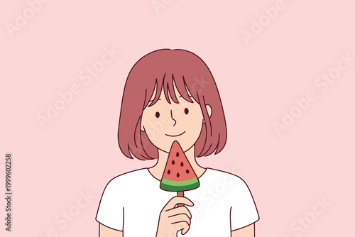 A young woman in a white t-shirt happily eating a cold popsicle shaped like a watermelon slice. Represents summer treats, childhood joy, and cooling down in the heat.