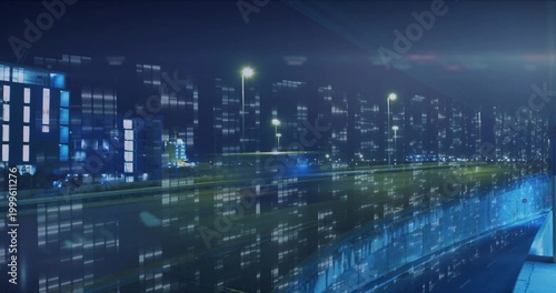 Showing elevated highway carrying light trails in nighttime business district, reflecting windows