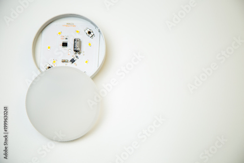 A small open light bulb with microcircuits and light elements inside lies on the side on a white background with space for text. Lighting concept, LED lamps. High quality photo 