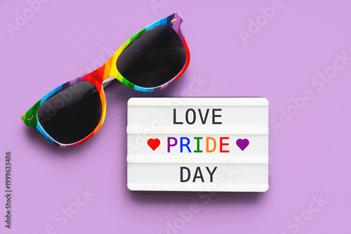 Closeup of LGTBI flag sunglasses and lightbox with the word Love, Pride day. LGBT Pride concept
