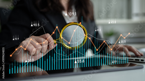 Photos Business professional focuses on data analysis with financial graphs and charts, utilizing a magnifying glass for detailed insights and informed decision making