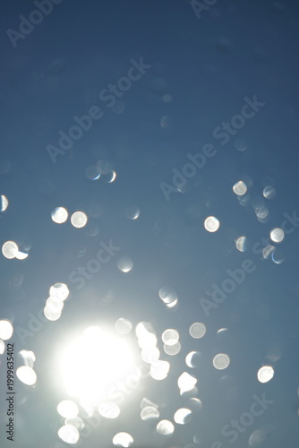 Abstract photo of water splashing on glass in front of the sun.Abstract photo of water splashing on glass in front of the sun.