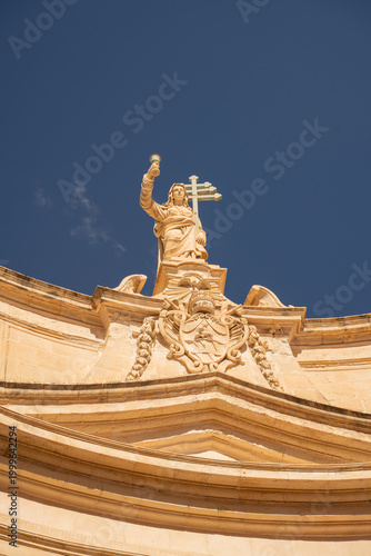 Vertical low angle view of St. Catherine of Italy church facade in Valletta. Baroque architecture and limestone statues in Malta.
