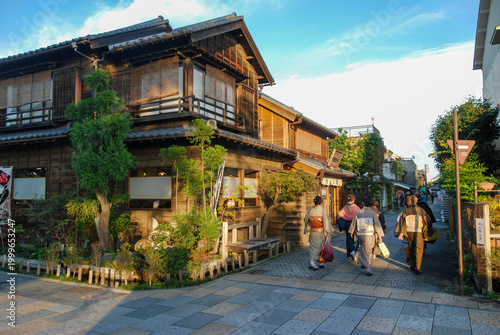 Obraz na plátně Women in traditional kimonos walking along a historic street with wooden houses