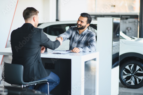Fotografía Client and salesman shaking hands sealing car deal at dealership