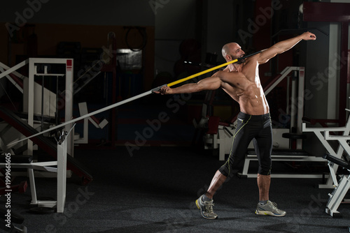 Side view Of Muscular Bodybuilder Throwing Javelin