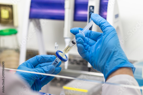 Fotografie The scientist filters the solution from the syringe through a disc filter into a test tube, separating the liquid from the particles