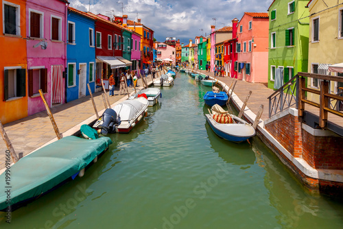 Colorful canal houses and boats on Burano Island in Venice Italy
