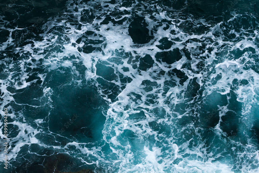 Fototapeta premium Top view of turquoise ocean water with white foam and splashes