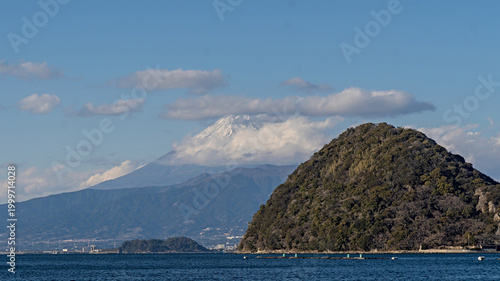 Iconic Mount Fuji vista with lush green island and blue ocean waters