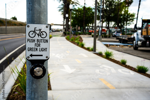 Photography Bicycle crossing signal button on a pole with a dedicated bike lane
