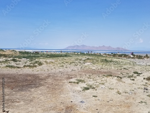 Expansive view of the Great Salt Lake shoreline under a bright blue sky.