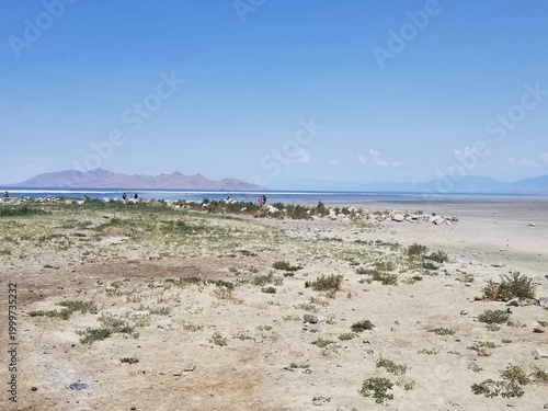 Expansive view of the Great Salt Lake shoreline under a bright blue sky.