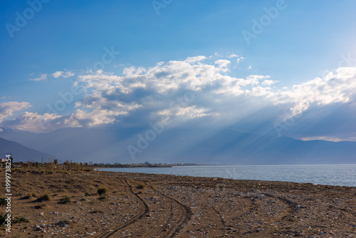 Sunlit rocky beach at sunset with crepuscular rays