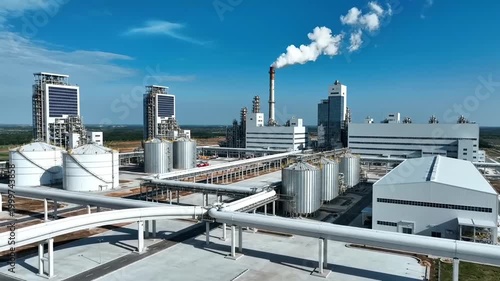 Aerial View of Industrial Plant with Smoking Chimney and Storage Tanks.