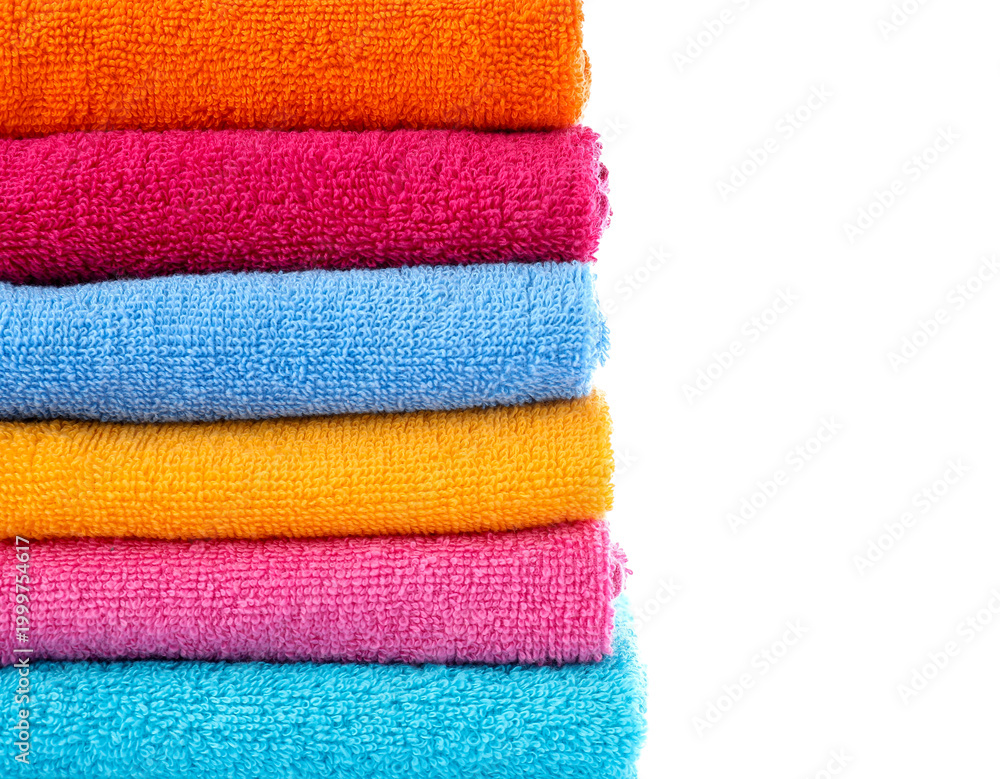 Obraz premium Stack of folded colorful terry towel isolated on white