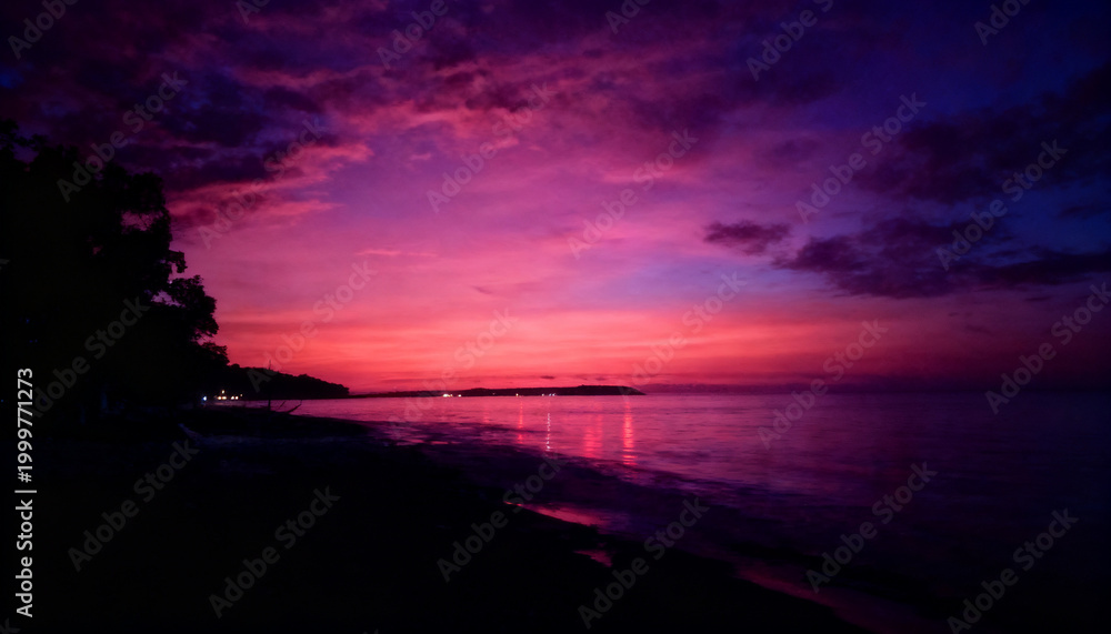 Obraz premium Vibrant Purple and Pink Dramatic Sunset Over the Ocean