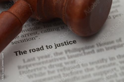 Close Up of Judicial Gavel on Legal Document with The Road to Justice Text