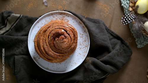 Freshly Baked Cinnamon Roll on a White Plate with Rustic Decor