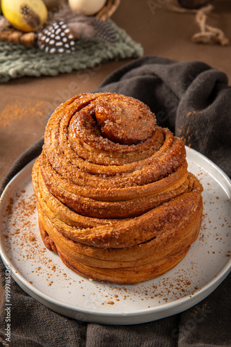 Freshly Baked Cinnamon Roll on White Plate with Easter Decor