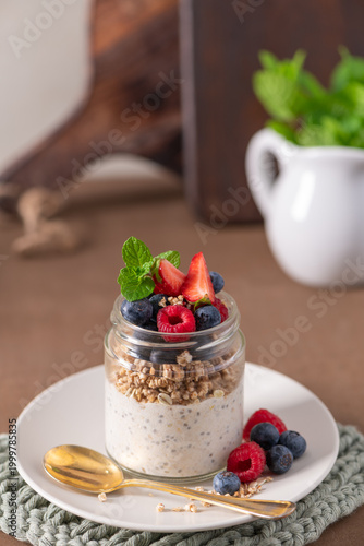 Overnight Oats with Chia Seeds Granola and Fresh Berries in a Glass Jar