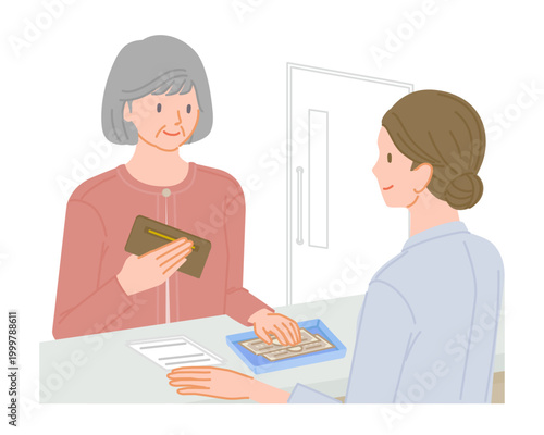 Senior woman paying medical bill with cash at hospital reception