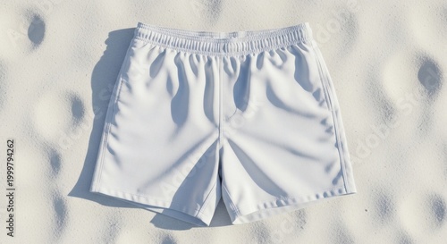 Plain White Men’s Swim Shorts Flat Lay on White Sand Beach Top-Down – Summer Apparel Product Photo