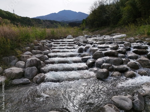 Clear stream flows over smooth river stones
