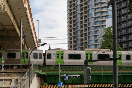 Train passing over a bridge in a modern Japanese city