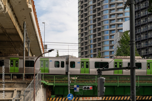 Train passing over a bridge in a modern Japanese city