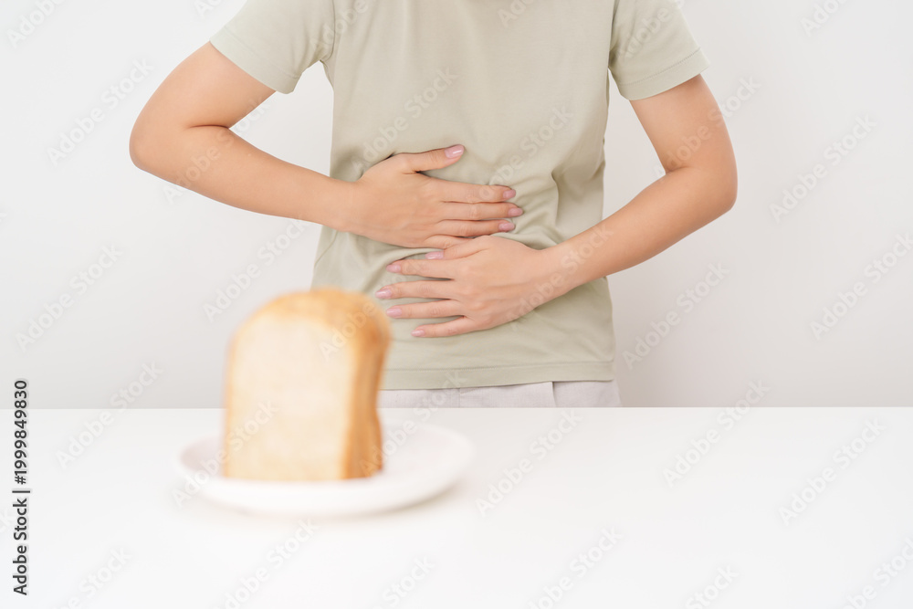 Fototapeta premium Gluten intolerance, Gluten free and celiac disease or Wheat allergy. woman with wheat bread and having abdominal pain after eat gluten. stomach ache, Nausea, Bloating, Gas, Diarrhea and Skin rash