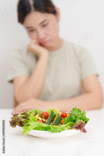 Bilde på lerret Unhappy woman disgust gesture and Bored to eat fresh organic vegetables