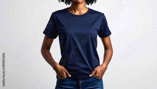 Plain dark navy blue short-sleeved crew neck t-shirt modeled by a person with hands in pockets against a plain background