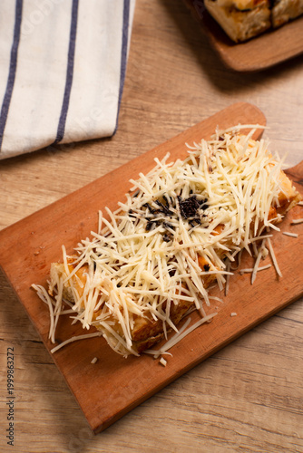 Roti Bakar Keju, Sandwich Bread Toast with Shredded Cheese. Popular Street Food from West Java. Perfect for recipe, article, catalogue, or any commercial purposes. with copy space.