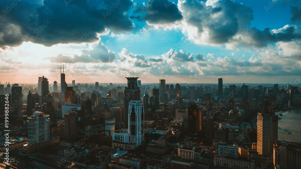 Obraz premium Aerial view of modern city skyline at sunset with dramatic clouds and river
