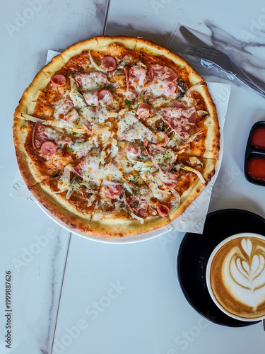 Pizza and coffee latte on a white marble table, photographed from above