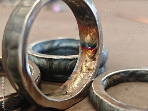 Close up of root pass weld with visible welding defect on metal ring joint. Industrial fabrication inspection concept showing poor weld penetration, flaw detection, and repair requirement.