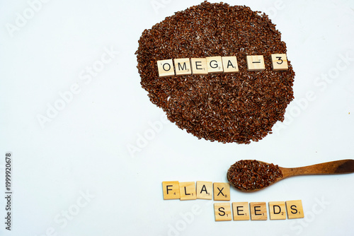Flax seeds with wooden alphabet blocks spelling omega 3 on white background