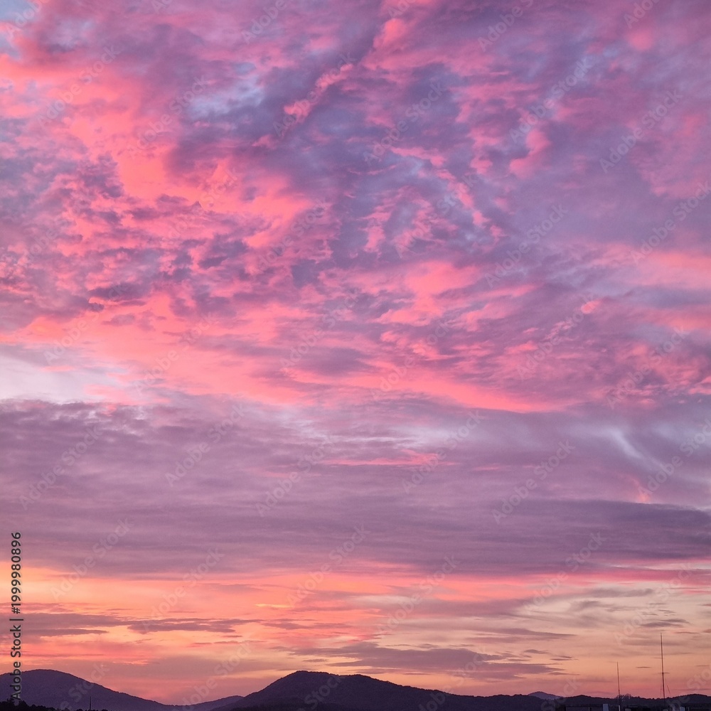 Obraz premium Pink Sunset Clouds Above Dark Mountain Landscape