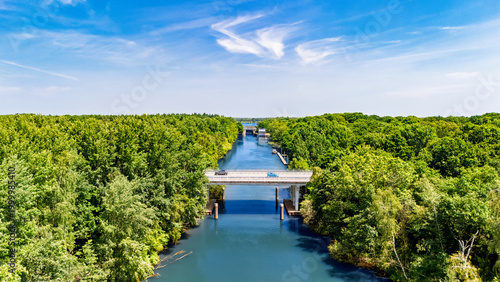 Aerial drone view of cars crossing bridge over river, forest landscape and modern road bridge, transportation and infrastructure in the Netherlands