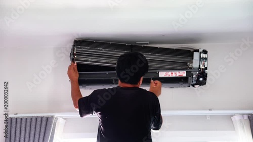 Professional technician disassembling and carefully reassembling a wall-mounted air conditioner blower fan during a deep cleaning and maintenance service.