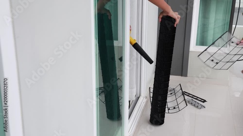 Professional HVAC technician using a portable electric blower to dry a clean black blower wheel and air filter components after washing.