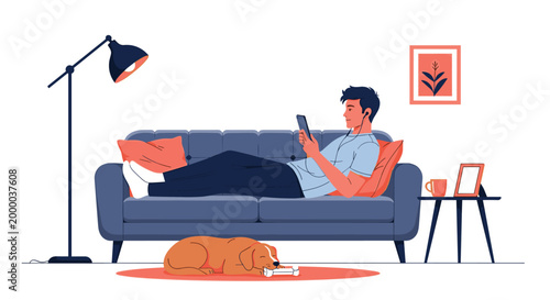 Man relaxes on a blue sofa while using a digital tablet and listening to music as his loyal dog sleeps on a rug on the living room floor.