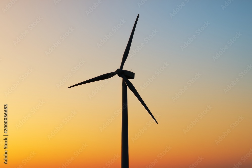 Fototapeta premium Wind turbine silhouette against vibrant gradient sunset sky background with soft light and clean energy concept in creative composition. Ai generative