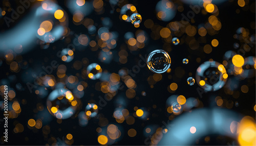 Photos bubbles floating in dark liquid with golden bokeh background closeup