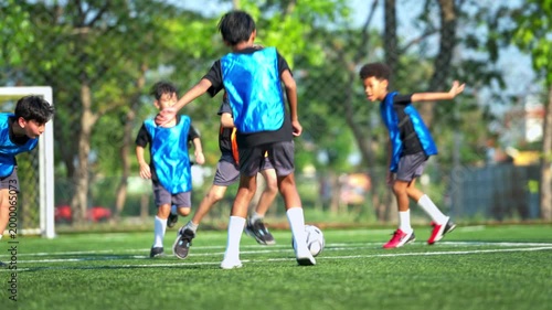 Football coach training international school students on the field, guiding teamwork and skill development in youth sports education