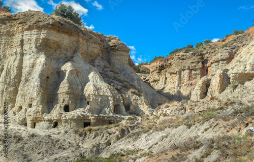 Fotografie view from outdoor of ancient troglodyte dwellings in cliff  in the Bardenas dese