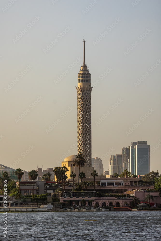 Obraz premium Cairo Tower Rising Above Nile Riverbank with Modern Skyline