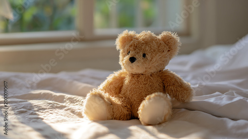 A soft teddy bear sitting on a bed in the morning sunlight