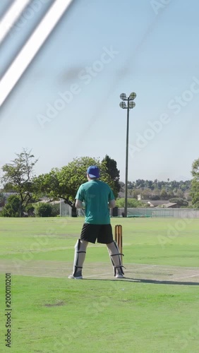 Vertical video: Batsman adjusting sports pitch for shot while bowler bowling overlays hiding stumps